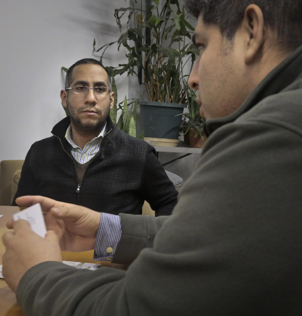 Javier Gallardo, left, a day laborer coordinator with the Bay Parkway Community Job Center in Besonhurst, N.Y., meets with Allan Suarez, a contractor who hires workers from the center, on Wednesday, Dec. 11, 2013 in New York. (AP Photo/Bebeto Matthews)