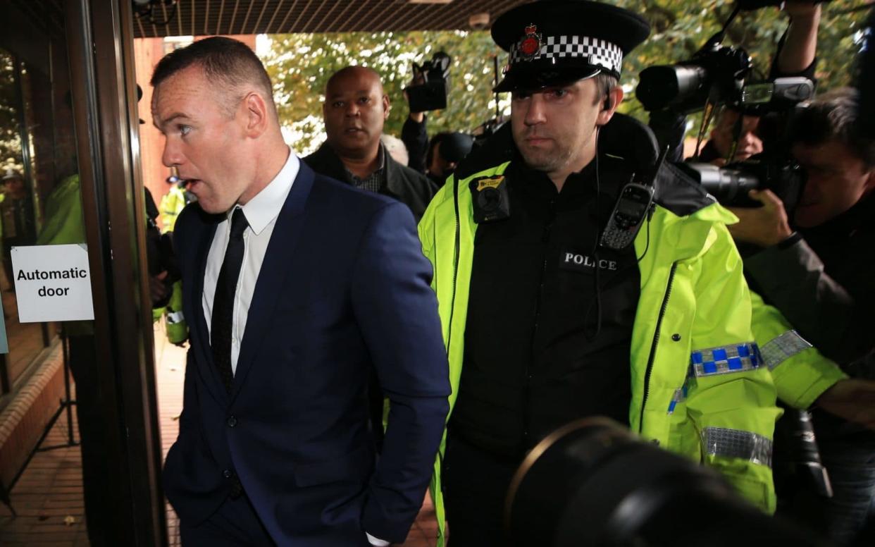 A police officer guides Wayne Rooney's arrival at court - PA