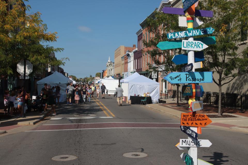 A signpost at the four corners in downtown Adrian directs visitors to different features of the Artalicious Fine Arts Fair Sept. 18, 2021.