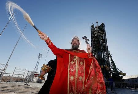 An Orthodox priest conducts a blessing in front of the Soyuz MS-04 spacecraft set on the launchpad ahead of its upcoming launch, at the Baikonur cosmodrome in Kazakhstan, April 19, 2017. REUTERS/Shamil Zhumatov TPX IMAGES OF THE DAY