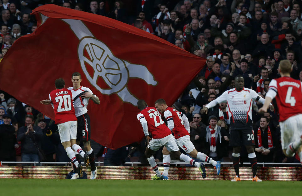 Arsenal's Lukas Podolski, center right, celebrates his goal against Liverpool with teammates during their English FA Cup fifth round soccer match at Emirates Stadium in London, Sunday, Feb. 16, 2014. (AP Photo/Sang Tan)