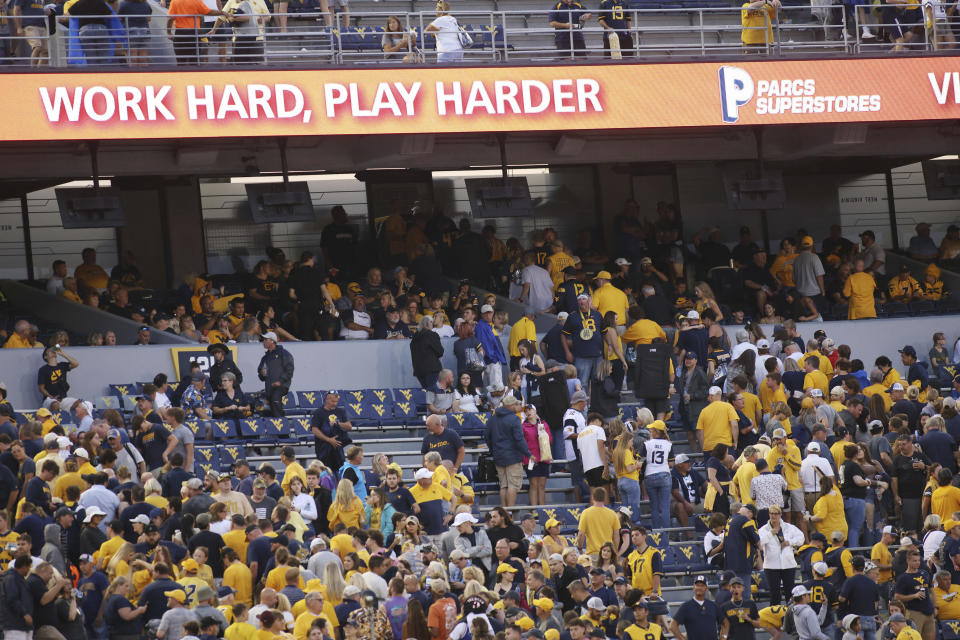 West Virginia fans head for the stadium concourse after the game was delayed due to severe weather during the first half of an NCAA football game against Duquesne, Saturday, Sept. 9, 2023, in Morgantown, W.Va. (AP Photo/Chris Jackson)