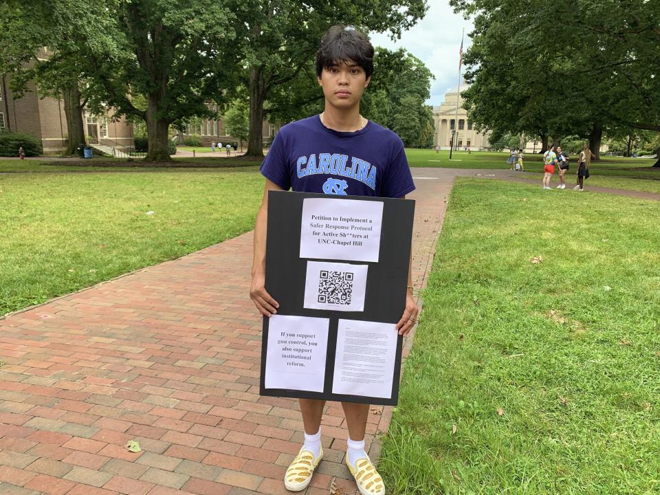 Micah Baldonado, a biomedical engineering student from Charlotte, N.C., holds his petition for improvements to the UNC-Chapel Hill active shooter response protocol on campus, Wednesday, Aug. 30, 2023, days after a shooting at the university. (AP Photo/Hannah Schoenbaum)