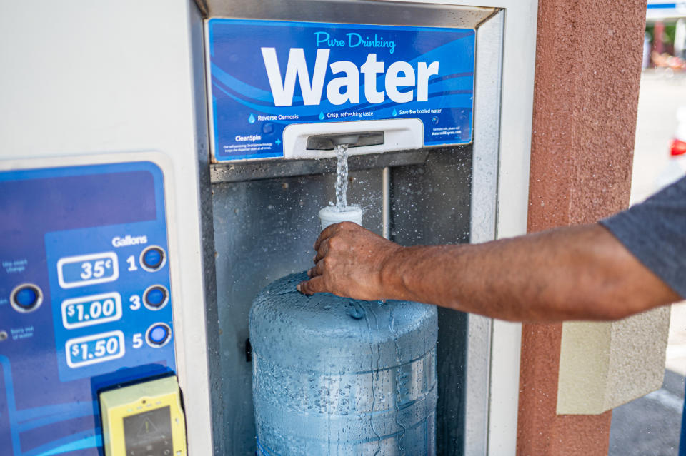 A resident fills a five-gallon jug of water at a vending machine.