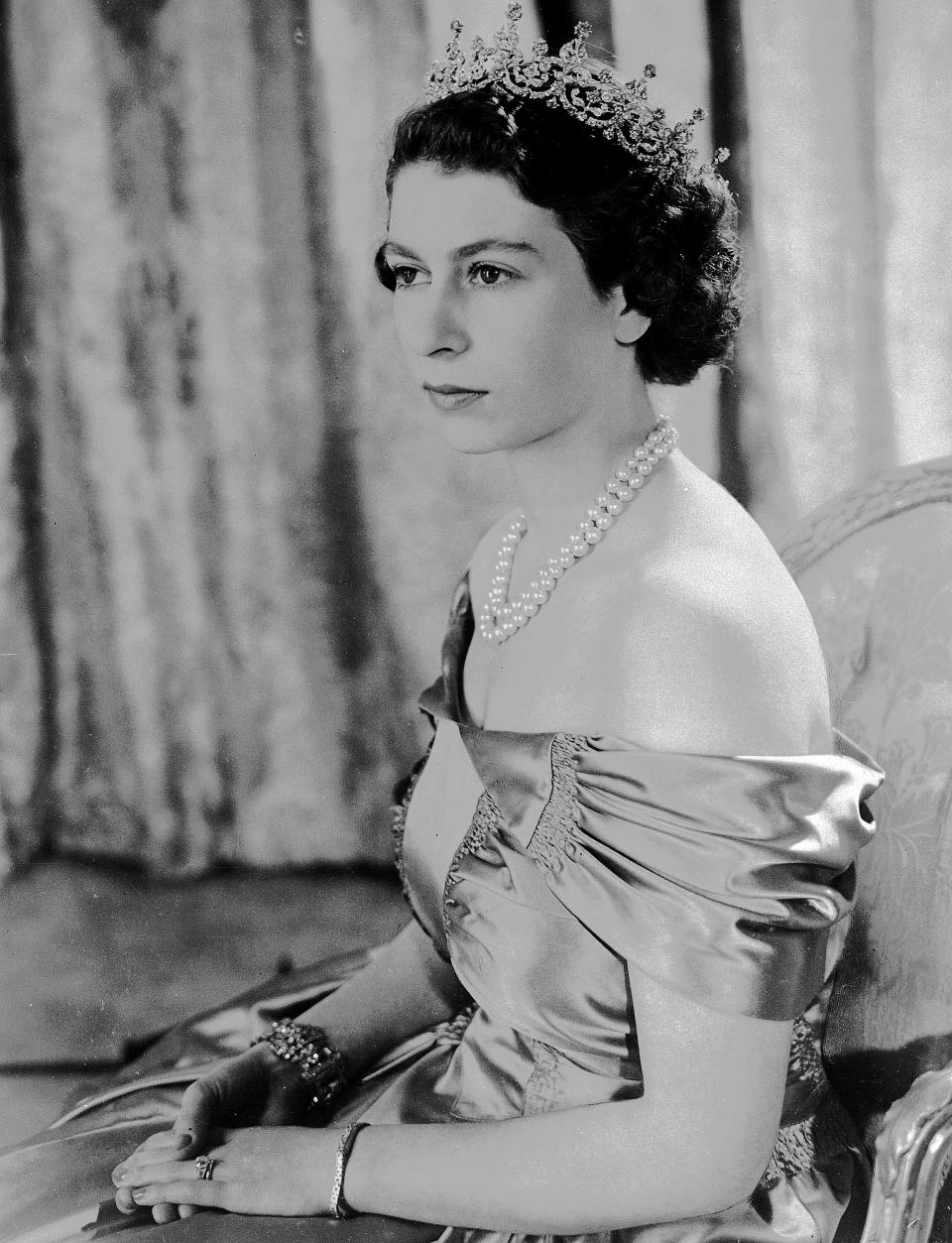 FILE - Britain's Queen Elizabeth II, then Princess Elizabeth, wears a silver gown with a diamond tiara and pearl necklace, in this Aug. 30, 1949 photo. Queen Elizabeth II will mark 70 years on the throne Sunday, Feb. 6, 2022, an unprecedented reign that has made her a symbol of stability as the United Kingdom navigated an age of uncertainty. (AP Photo, File)
