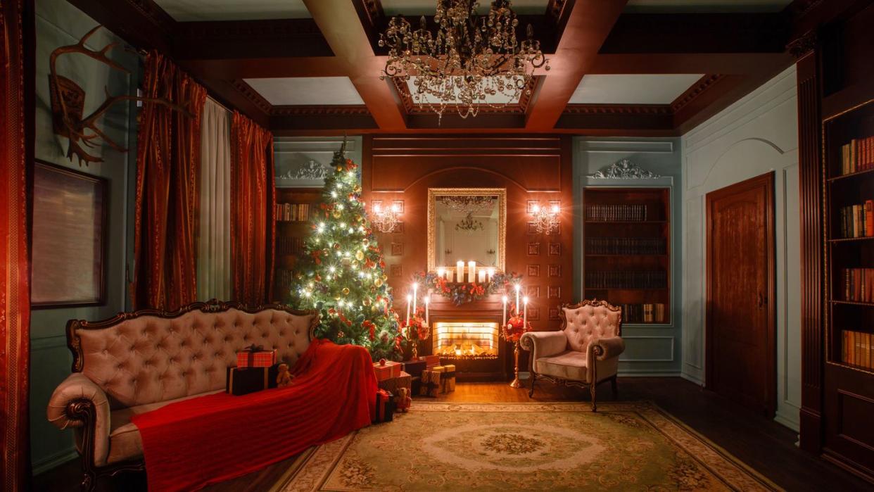 calm image of interior classic new year tree decorated in a room with a fireplace