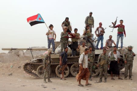 Members of UAE-backed southern Yemeni separatist forces stand atop a tank during clashes with government forces in Aden