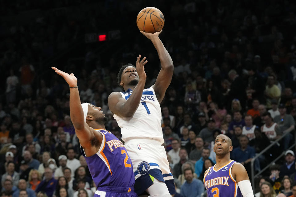 Minnesota Timberwolves guard Anthony Edwards (1) drives past Phoenix Suns forward Josh Okogie (2) as Suns guard Chris Paul, right, looks on during the first half of an NBA basketball game Wednesday, March 29, 2023, in Phoenix. (AP Photo/Ross D. Franklin)