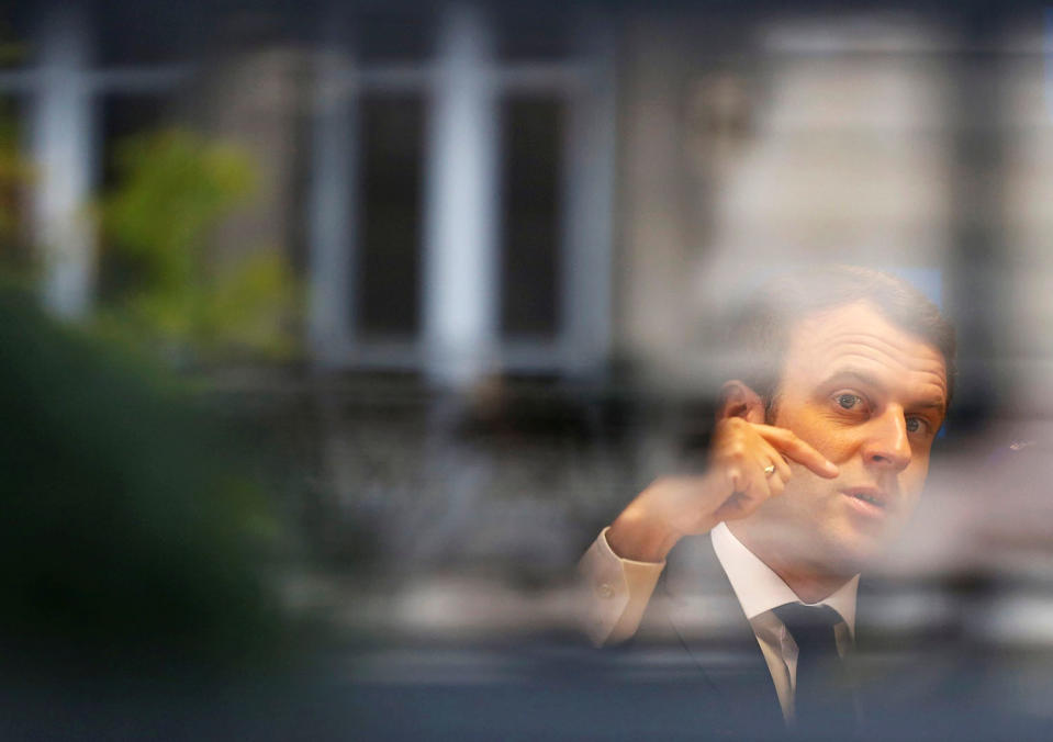 Emmanuel Macron is pictured through a window in Rodez