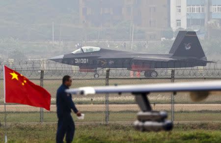 A J-31 stealth fighter (background) of the Chinese People's Liberation Army Air Force lands on a runway after a flying performance at the 10th China International Aviation and Aerospace Exhibition in Zhuhai, Guangdong province, in this November 11, 2014 file photo. REUTERS/Alex Lee/Files