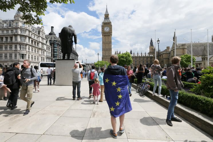 A demonstrator wrapped in the EU flag takes part in a protest opposing Britain's exit from the European Union in Parliament Square following yesterday's EU referendum result, London, Saturday, June 25, 2016.(AP Photo/Tim Ireland)