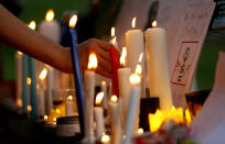 A women's rights activist places a candle beside a poster during a candle light vigil to pay tribute to Noor Mukadam, who was recently beheaded, and other domestic violence victims in Islamabad, Pakistan, Sunday, July 25, 2021. The killing of Mukadam in an upscale neighborhood of Pakistan's capital has shone a spotlight on the relentless violence against women in the country. Rights activists say such gender-based assaults are on the rise as Pakistan barrels toward greater religious extremism. (AP Photo/Anjum Naveed)