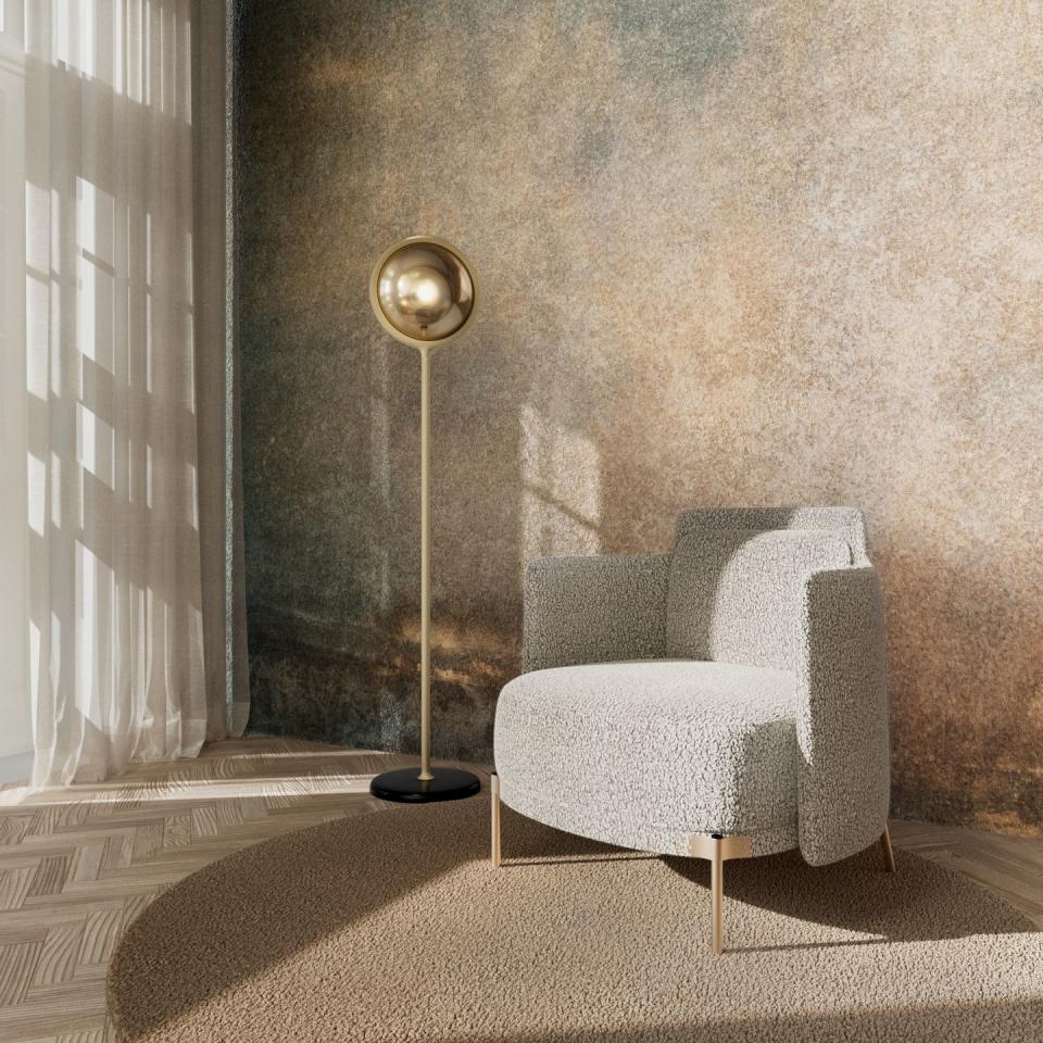 a gold floor lamp next to a white chair