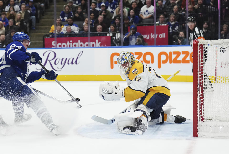 Toronto Maple Leafs forward David Kampf (64) scores on Nashville Predators goaltender Kevin Lankinen (32) during the second period of an NHL hockey game Saturday, Dec. 9, 2023, in Toronto. (Nathan Denette/The Canadian Press via AP)