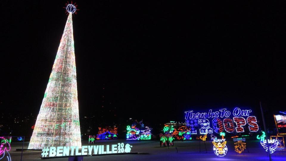 tall tree filled christmas lights sign in lights reading bentleyville 2020 and a sign reading thanks to our troops