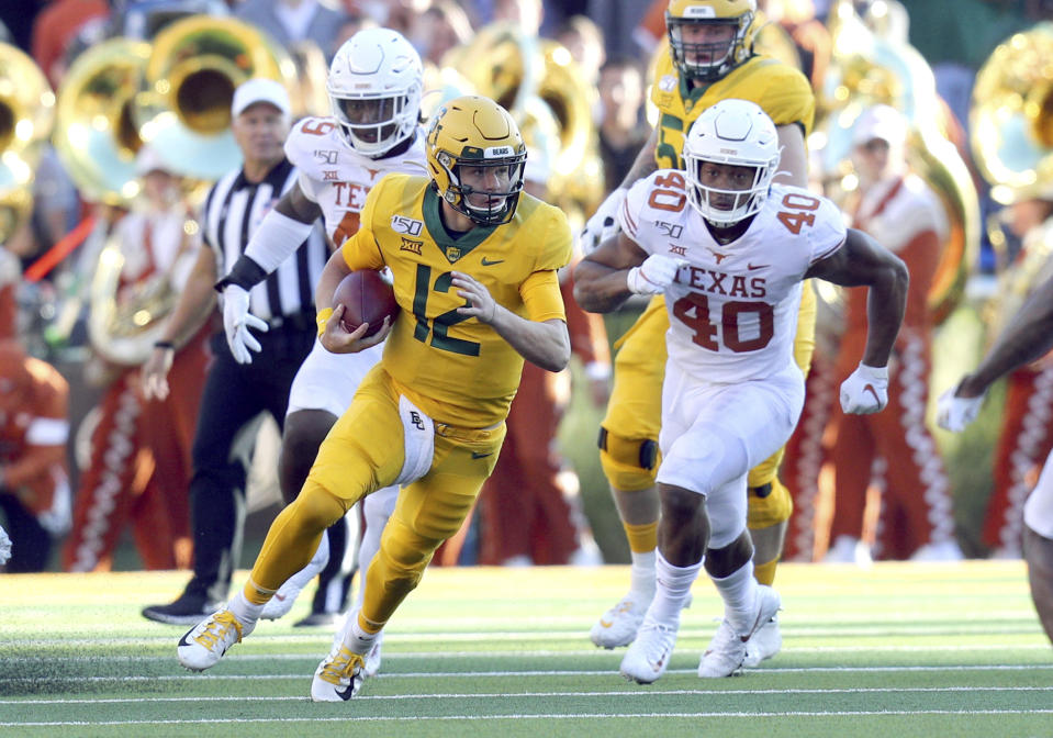 Baylor quarterback Charlie Brewer (12) runs the ball as he is pursued by Texas linebacker Ayodele Adeoye (40) In an NCAA football game Saturday, Nov. 23, 2019, in Waco, Texas. (AP Photo/Richard W. Rodriguez)