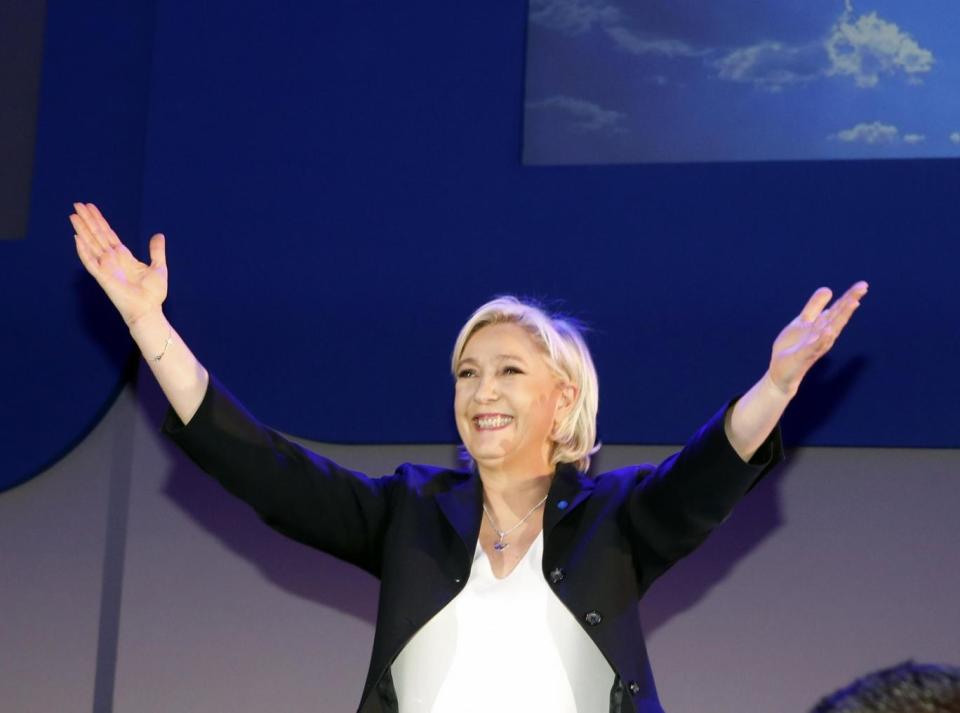 Marine Le Pen cheers supporters on stage after exit poll results of the first round of the presidential election were announced at her election day headquarters (AP)