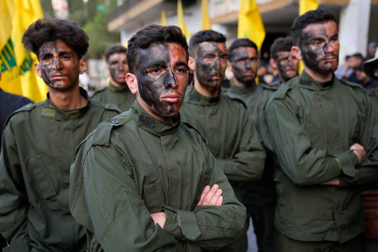 Combatientes de Hezbollah asisten a una procesión fúnebre de dos de sus compañeros que murieron por artillería israelí, el martes 10 de octubre de 2023, en el poblado de Khirbet Selm, en el sur de Líbano. El grupo respaldado por Irán anunció la noche del lunes que tres de sus elementos fallecieron luego de un intenso ataque de Israel en contra de localidades fronterizas en el sur de Líbano. 