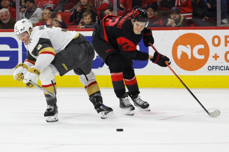 Vegas Golden Knights’ Brayden McNabb (3) and Carolina Hurricanes’ Jesse Puljujarvi (13) watch the loose puck during the second period of an NHL hockey game in Raleigh, N.C., Saturday, March 11, 2023. (AP Photo/Karl B DeBlaker)