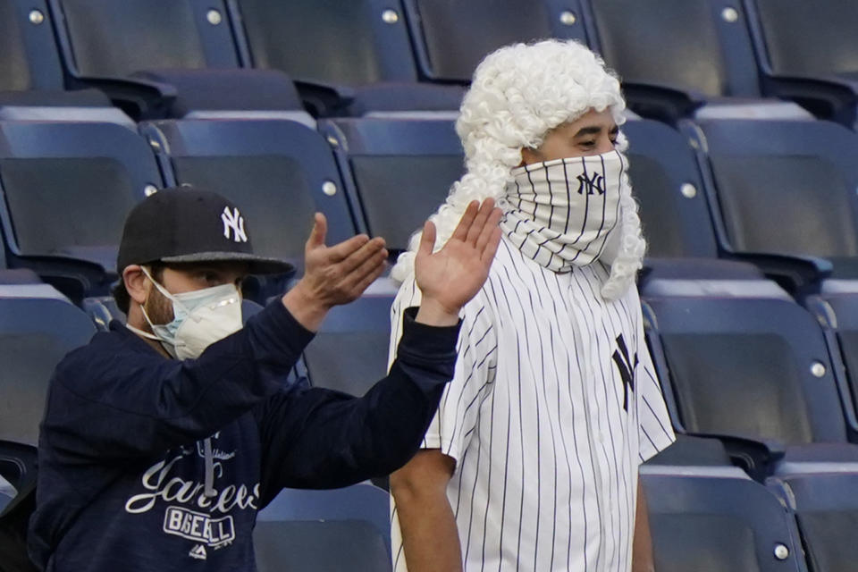 Fans of New York Yankees right fielder Aaron Judge (99) gesture "all rise" as Judges take the field before the start of a baseball game against the Baltimore Orioles, Monday, April 5, 2021, at Yankee Stadium in New York. (AP Photo/Kathy Willens)