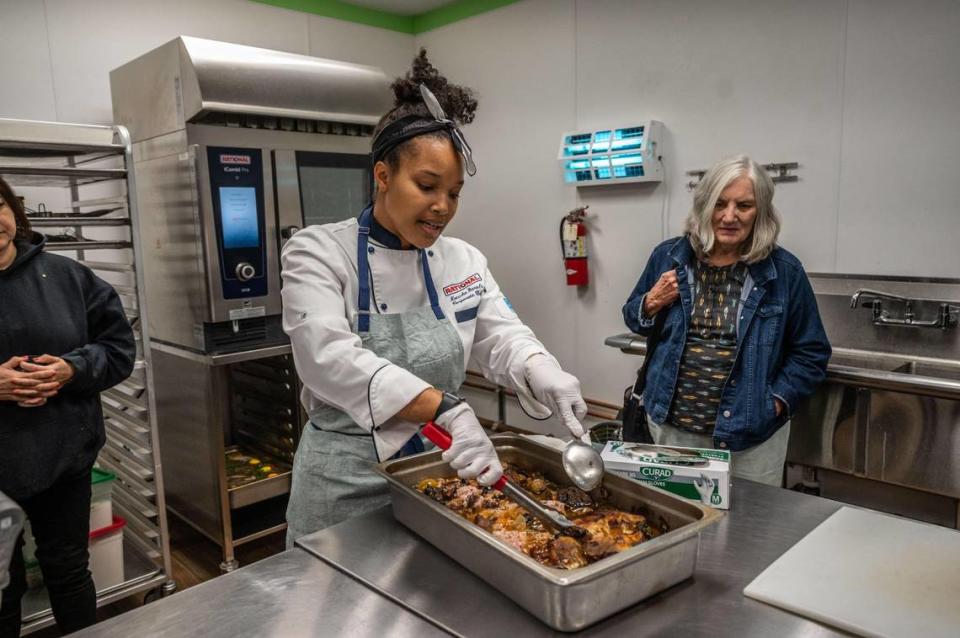 Natasha Daniels, a corporate chef for Rational USA, checks the tenderness of pork that was cooked using the iCombi Pro electric oven during a demonstration on the benefits of electric cooking.