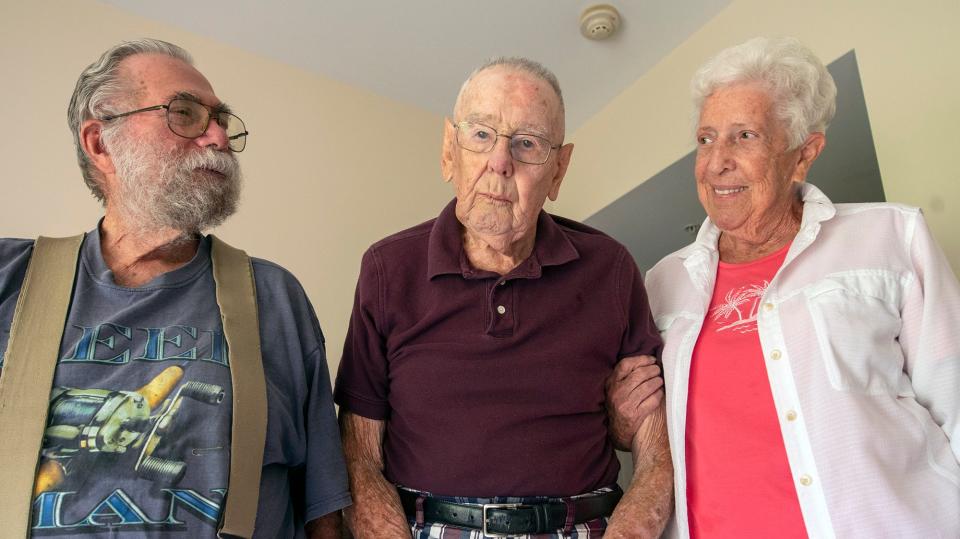 Leroy Krebs, center, stands with class of 1957 student Marian Williams.