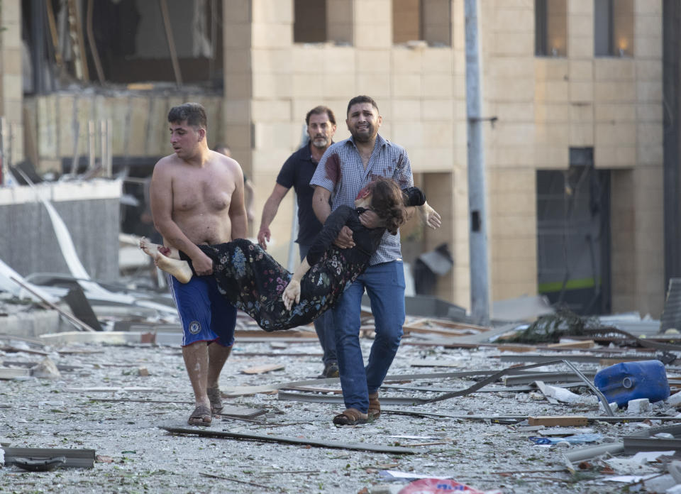 Wounded people are evacuated after a massive explosion in Beirut, Lebanon, Tuesday, Aug. 4, 2020. Massive explosions rocked downtown Beirut on Tuesday, flattening much of the port, damaging buildings and blowing out windows and doors as a giant mushroom cloud rose above the capital. Witnesses saw many people injured by flying glass and debris. (AP Photo/Hassan Ammar)