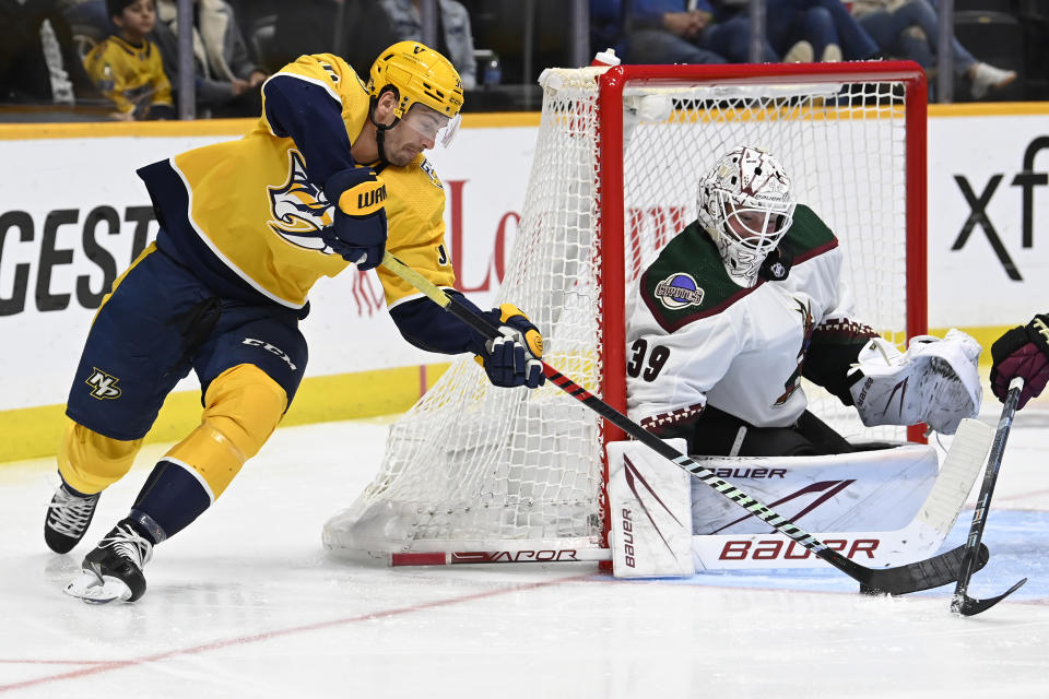 Arizona Coyotes goaltender Connor Ingram (39) defends the goal against Nashville Predators left wing Cole Smith, left, during the second period of an NHL hockey game Saturday, Feb. 10, 2024, in Nashville, Tenn. (AP Photo/Mark Zaleski)