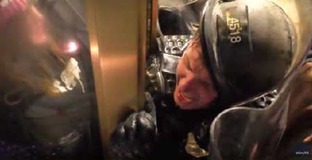 A clear police riot shield is pressed up against Officer Daniel Hodges as he is pinned against a door at the U.S. Capitol on Jan. 6, 2021.  (U.S. District Court for the District of Columbia )