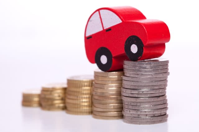 red car over a lot of stacked coins