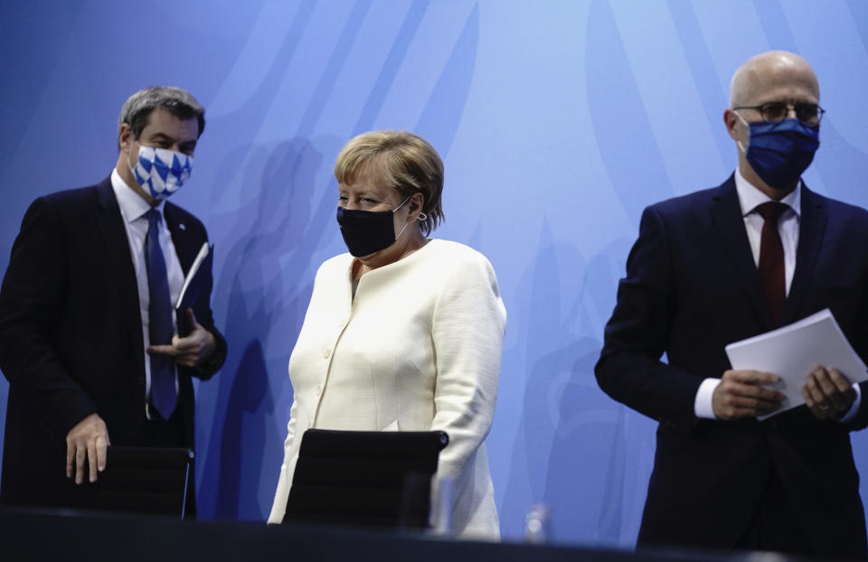 German Chancellor Angela Merkel, centre, Markus Soder, Prime Minister of Bavaria and CSU Chairman, left and Peter Tschentscher, the First Mayor of Hamburg, leave after a press conference, in Berlin, Tuesday, Sept. 29, 2020. Chancellor Angela Merkel and the governors of Germany’s 16 states conferred on how to prevent the country’s coronavirus infection figures from accelerating to the levels being seen in other European countries. (Kay Nietfeld/dpa via AP)