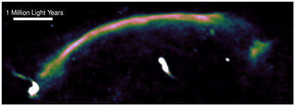 This radio image shows a shock wave (the bright arc running from bottom left to top right) in the 'Sausage' merging cluster of galaxies as seen by the Giant Metrewave Radio Telescope. The shock wave was generated 1 billion years ago, when the t