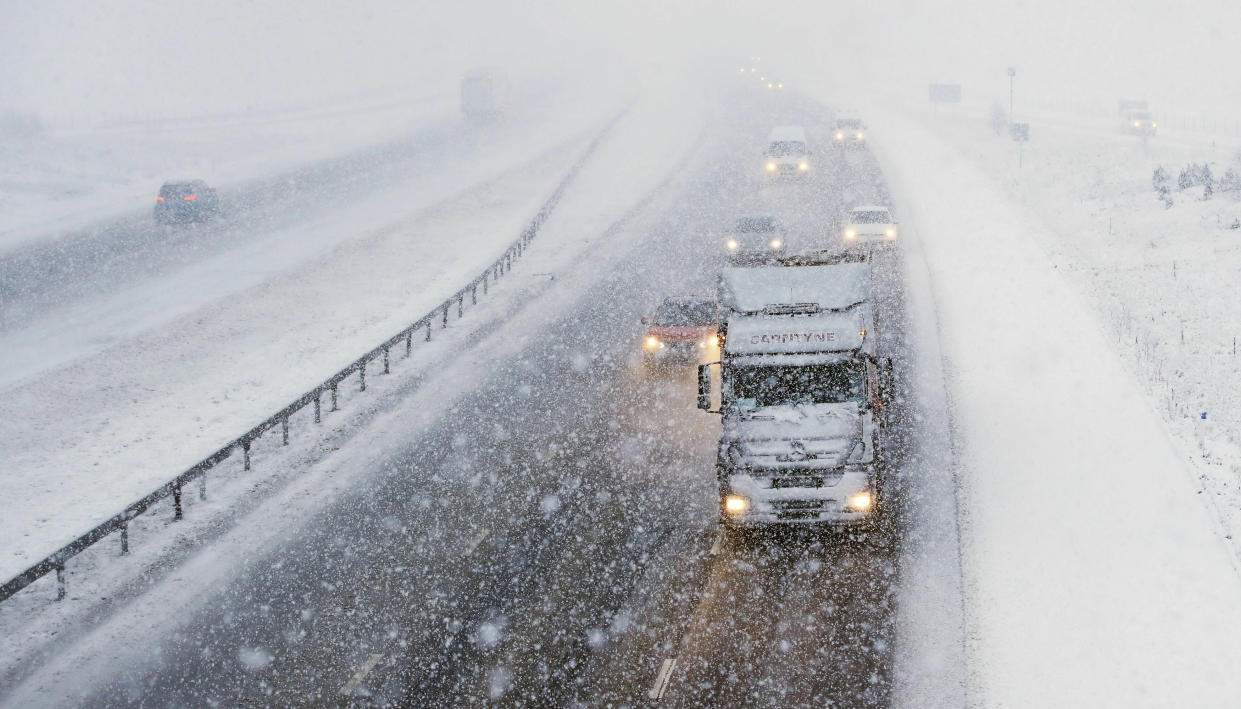 Traffic travels through snowfall on the M6 motorway near the village of Shap in Cumbria, north west England, Tuesday Jan. 29, 2019, as temperatures are expected to drop across large parts of Britain this week. Weather warnings for snow and ice have been issued by the Met Office. (Owen Humphreys/PA via AP)