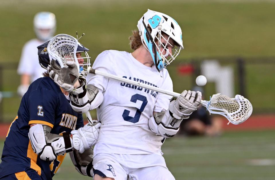 Cole Rodgers of Sandwich reaches to control the ball pressured by Jack Calichman of Lynnfield.