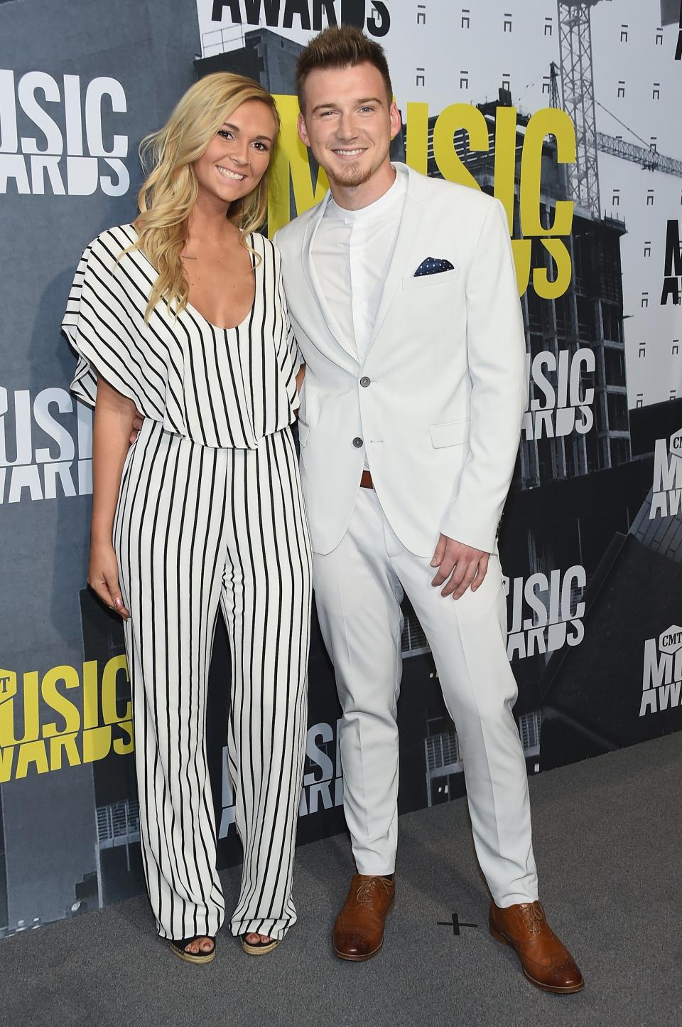 KT Smith in white and black striped jumpsuit with Morgan Wallen in white suit at CMT awards