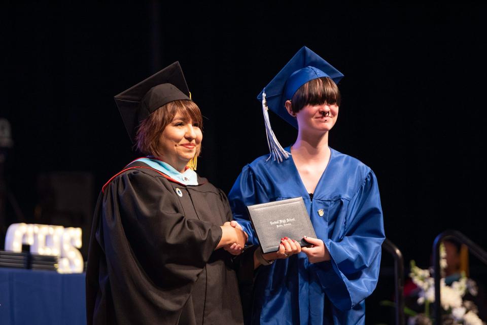 Alex Boterf, right, smiles and shakes the hand of D60 Superintendent Charlotte Macaluso after receiving their diploma at the Pueblo Central High School commencement ceremony on Saturday, May 27, 2023.