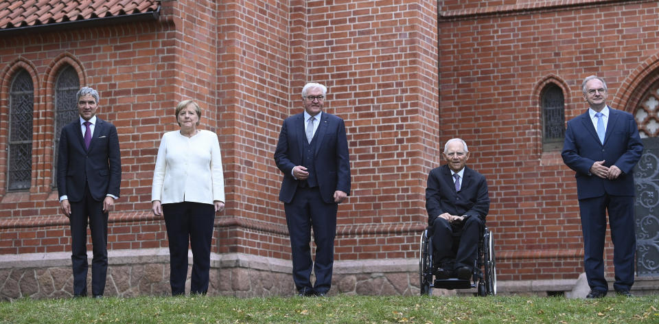 The top state representatives Stephan Harbarth, President of the Federal Constitutional Court, Federal Chancellor Angela Merkel , Federal President Frank-Walter Steinmeier, Parliament President Wolfgang Schaeuble and Federal council President Reiner Haseloff, from left, stand in front of St Paul's Church in Halle/Saale, Germany, before the start of the ecumenical service at the celebrations for the Day of German Unity on Sunday, Oct. 3, 2021. (Hendrik Schmidt/Pool via AP)