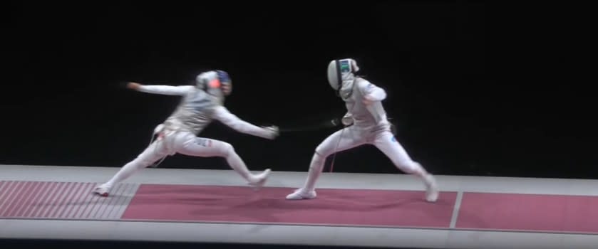 Fencer lunges forward with sword to hit her opponent