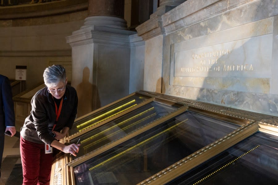 Amy Lubick, a supervisory conservator at the National Archives, runs a cotton swab over a display case that held the U.S. Constitution at National Archives in Washington on Thursday, Feb. 15, 2024. The National Archives building and galleries were evacuated on Feb. 14 after two protesters dumped powder on the protective casing around the U.S. Constitution. (AP Photo/Amanda Andrade-Rhoades)