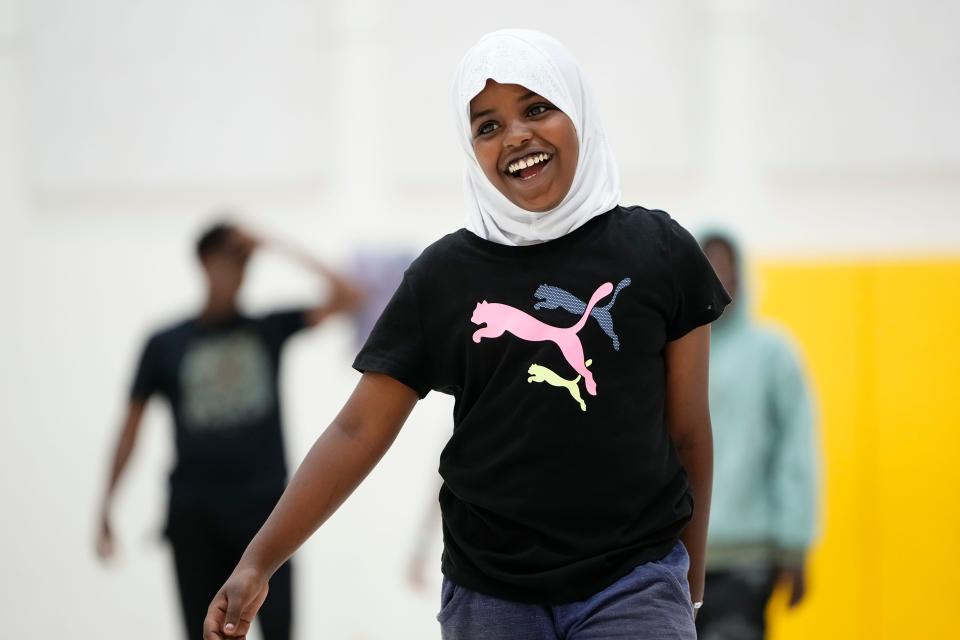 Balqisah Haji, 10, laughs during a Neighborhood Athletics basketball practice Tuesday at Sullivant Elementary on the West Side.