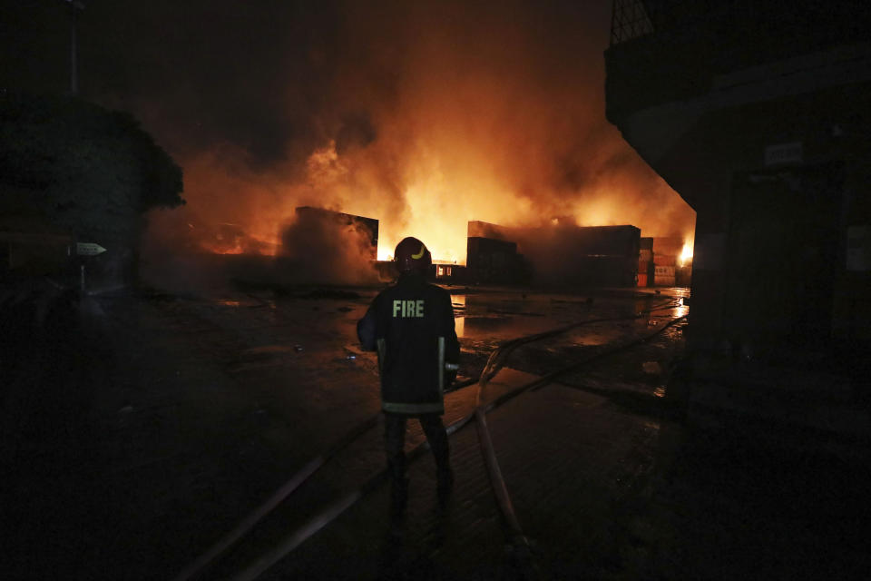 A firefighter works to contain a fire that broke out at the BM Inland Container Depot, a Dutch-Bangladesh joint venture, in Chittagong, 216 kilometers (134 miles) southeast of capital, Dhaka, Bangladesh, early Sunday, June 5, 2022. Several people were killed and more than 100 others were injured in the fire the cause of which could not be immediately determined. (AP Photo)