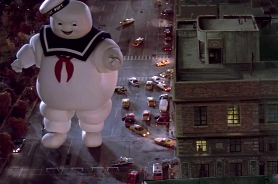 large marshmallow man walking in a the city street