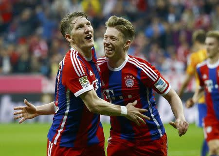 Bayern Munich's Bastian Schweinsteiger celebrates with his team mate Mitchell Weiser (R) after scoring a goal against Hertha Berlin during their German Bundesliga first division soccer match in Munich April 25, 2015. REUTERS/Kai Pfaffenbach