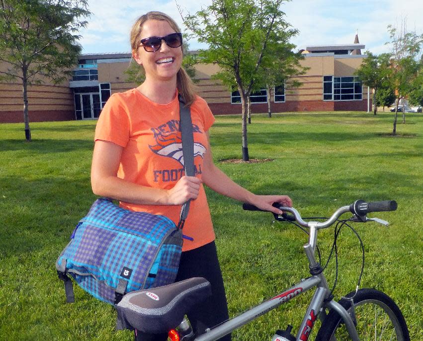 Jaclyn King, 28, smiles as she arrives at her job at a Denver hospital on Wednesday, June 27, 2012. King grew up in the suburbs of Denver and now lives in the city and says she’ll never return to the suburbs because she wants to avoid the long commutes her parents had. For the first time in a century, America's largest cities are growing at a faster rate than their surrounding suburbs as young adults seeking a foothold in the weak job market shun home-buying and stay put in bustling urban centers. (AP Photo/Kristen Wyatt)