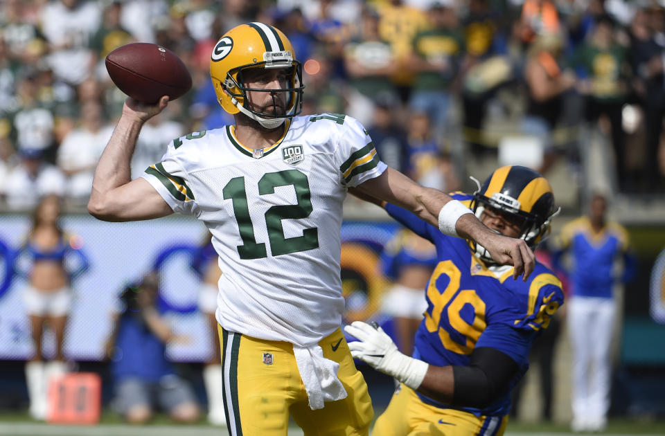 Green Bay Packers quarterback Aaron Rodgers (12) throws a pass under pressure from Los Angeles Rams defensive tackle Aaron Donald (99) during the first half of an NFL football game, Sunday, Oct. 28, 2018, in Los Angeles. (AP Photo/Denis Poroy)
