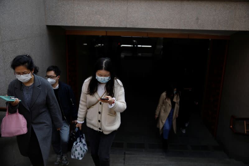 People wearing face masks exit a subway station following an outbreak of the coronavirus disease (COVID-19), in Beijing