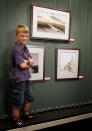 Kieron junto a sus cuadros en el 2010, en una exhibición en una galería de Norfolk.