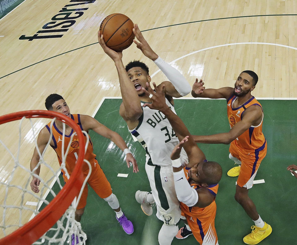 Milwaukee Bucks' Giannis Antetokounmpo (34) shoots over Phoenix Suns' Devin Booker, from left to right, Chris Paul and Mikal Bridges during Game 4 of basketball's NBA Finals, Wednesday, July 14, 2021, in Milwaukee. (Jonathan Daniel/Pool Photo via AP)