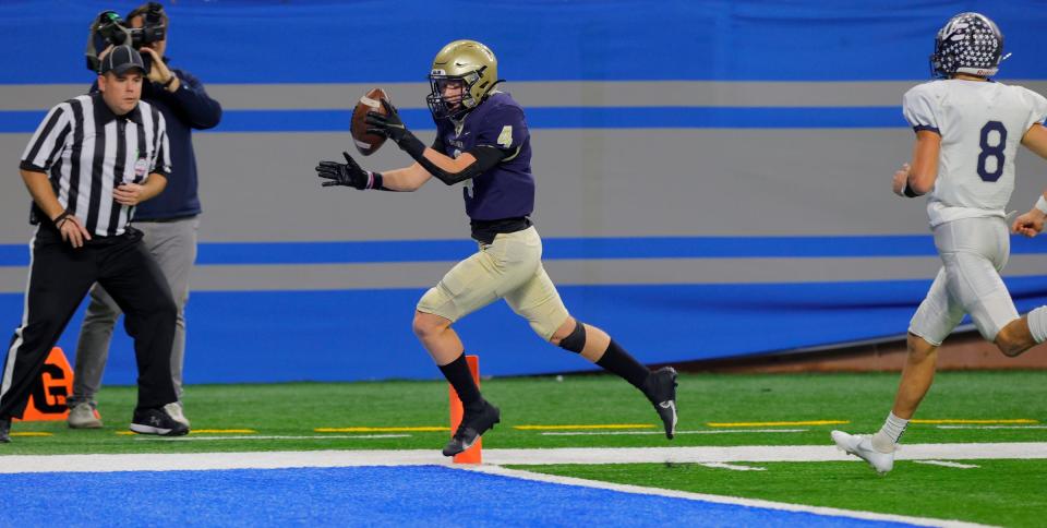 Chelsea #4 wide receiver Lucas Hanifan scores the first touchdown of the game as Hudsonville Unity Christian #8 Camron Chandler can't catch him in time during first half action the Michigan High School Athletic Association division four football game between the two schools at Ford Field in Detroit on Friday Nov, 26, 2021.