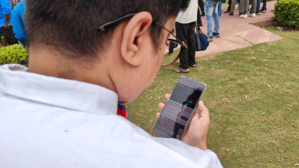 Amrita watches the verdict on their phone at the Supreme Court of India on October 17, 2023. - Tanushree Pandy/CNN